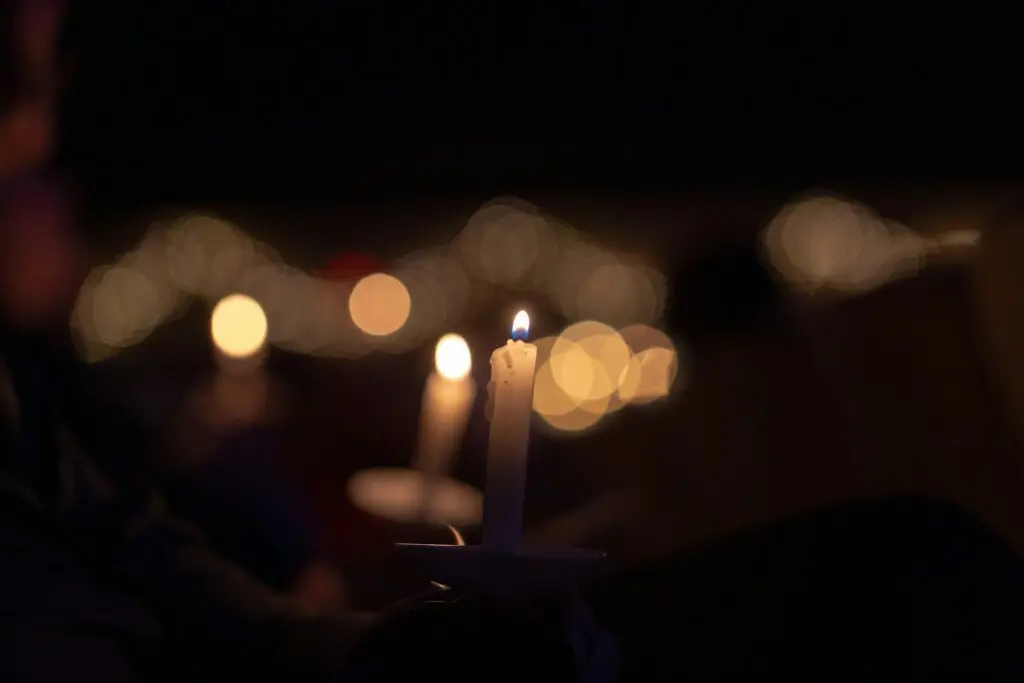 Person holding a lit candle at a Christmas Eve candlelight service