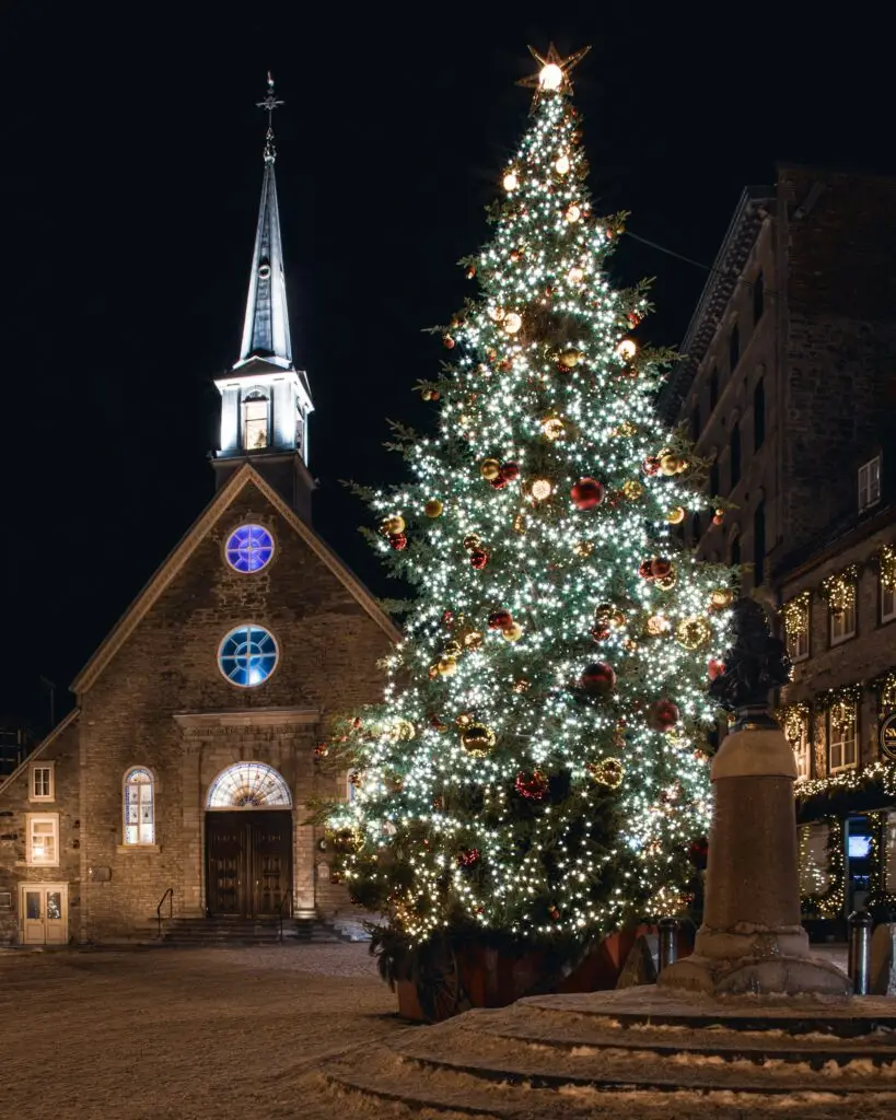 Lit Christmas tree in front of a church