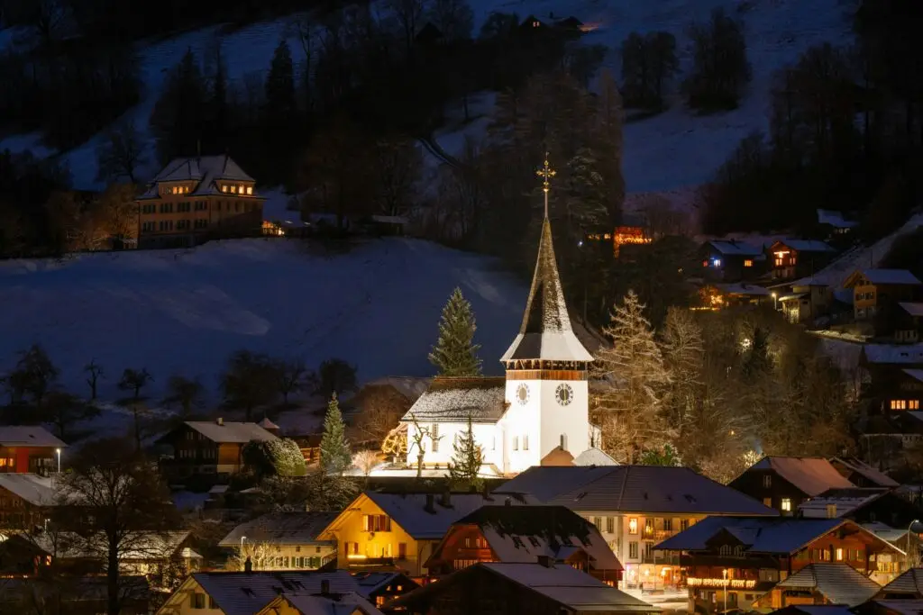 Church lit up at night in a snowy town at Christmas