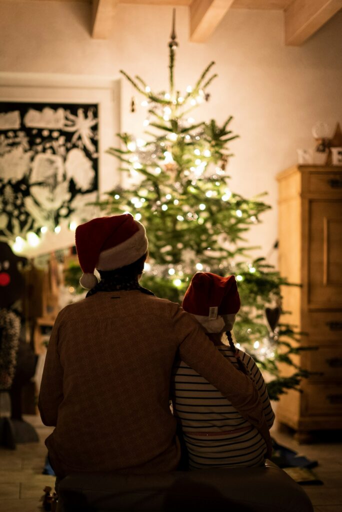 Mother and daughter hugging in front of a Christmas tree